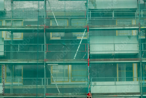 Fototapeta partial view of a residential building site secured with nets