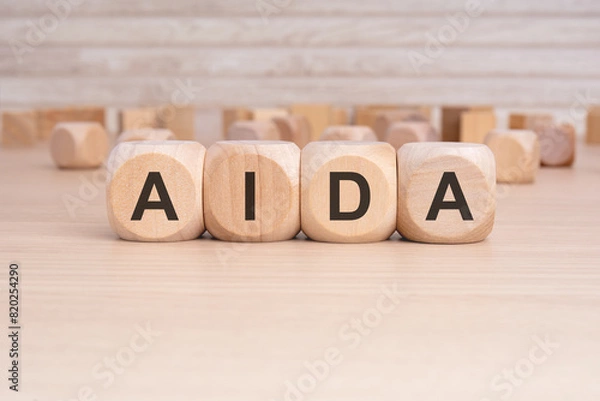 Fototapeta the acronym AIDA is elegantly displayed on a beige hardwood rectangle block