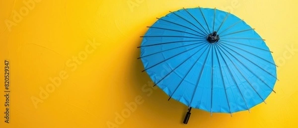 Obraz Blue umbrella with blank copyspace on yellow background