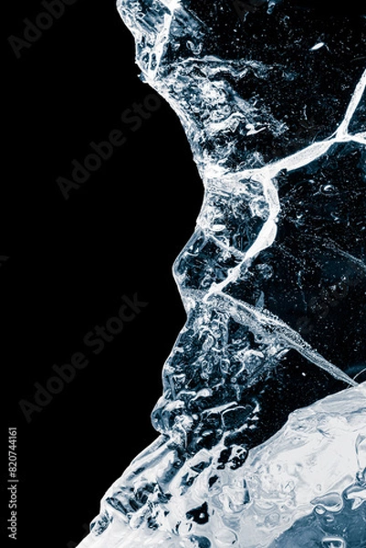 Fototapeta Pure transparent crushed ice piece with cracks on a black background.
