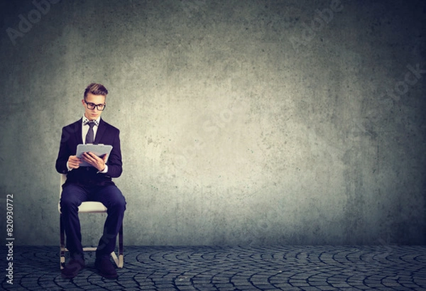 Fototapeta A job applicant sitting on a chair reading a contract  