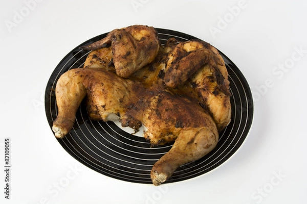 Obraz Roasted chicken on a striped black dish