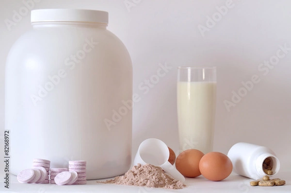 Fototapeta Big jar of protein powder, bottles, milk, pills and tablets