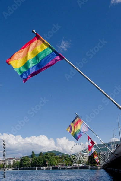 Fototapeta A six-band rainbow flag representing the LGBT community flutters in the wind on the Mont Blanc bridge and Lake Geneva