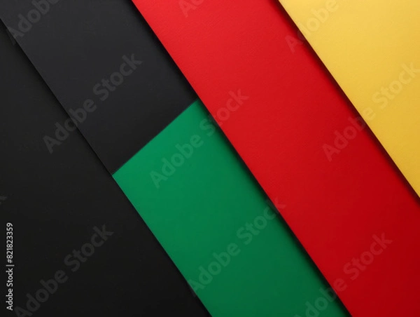Fototapeta Red, yellow, and green paper are arranged on a black backdrop to represent Black History Month.
