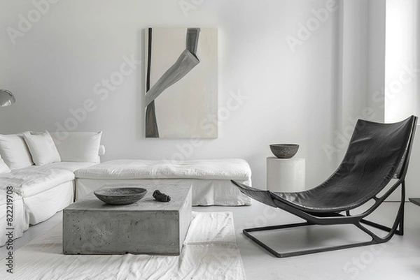 Fototapeta A chic minimalist living room with white walls, a low-profile white linen sofa, and a concrete coffee table