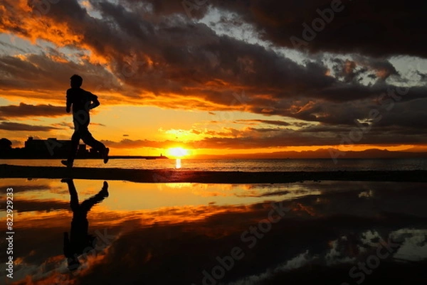 Obraz 夕暮れの逗子海岸、ランニングする若者のシルエット