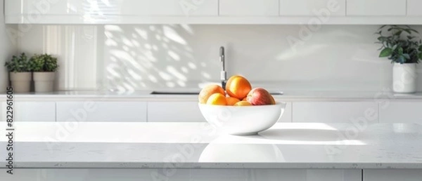Fototapeta Minimalist white kitchen with a single bowl of fruit on the counter, clean and modern design, bright natural light