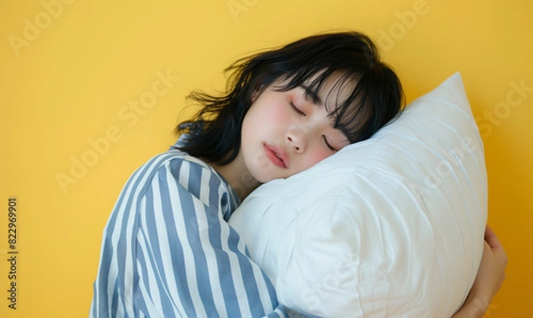 Fototapeta 枕を持って寝ているパジャマ姿の女性