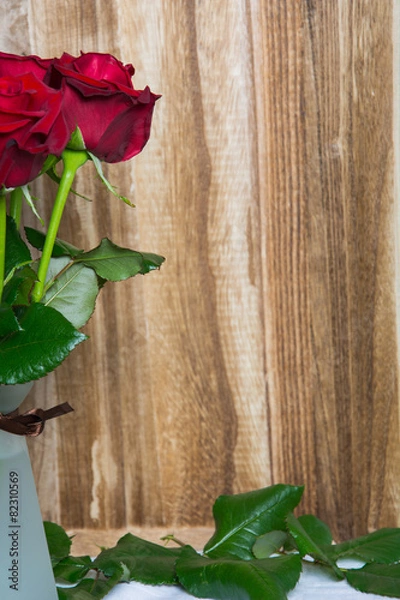 Fototapeta Red roses on wooden background with space for text