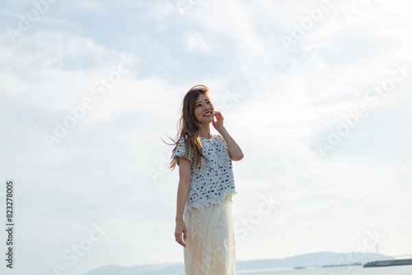 Fototapeta 海でたそがれている髪長い女性