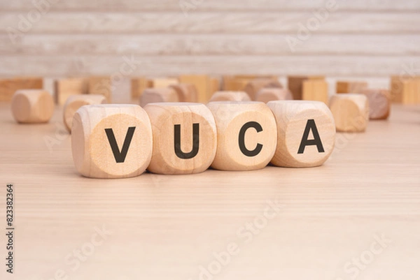 Fototapeta short word english text VUCA on a wooden cubes with wooden background