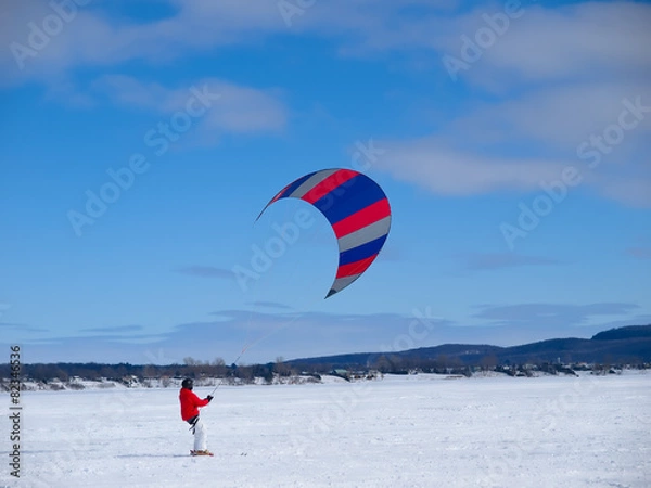 Fototapeta Men ski kiting on a frozen lake