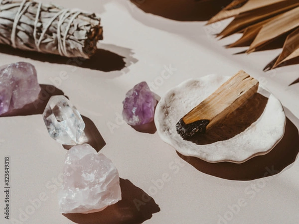 Fototapeta White sage and Palo Santo and amethyst and quartz crystals on a light beige background