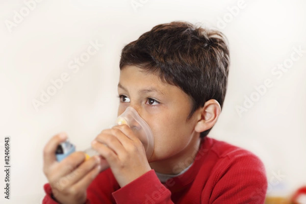 Obraz Young boy using inhaler on white background