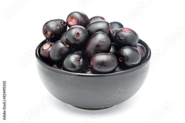 Fototapeta A black ceramic bowl filled with 'Indian blackberry' or Jamun (Syzygium cumini) fresh fruits. Isolated on a white background. Front view.
