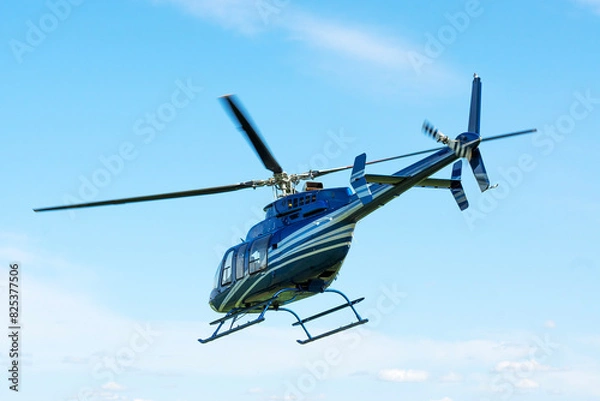 Fototapeta Bell helicopter in flight against the sky