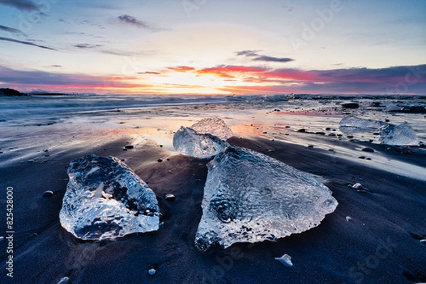 Fototapeta Ice floes during sunrise with spectacular colors on the black sands of Diamond Beach - Iceland