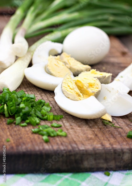 Fototapeta eggs, green onions, herbs on the table