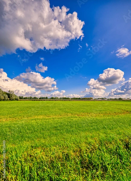Obraz Big cloud formations passing over a rural landscape in The Netherlands.