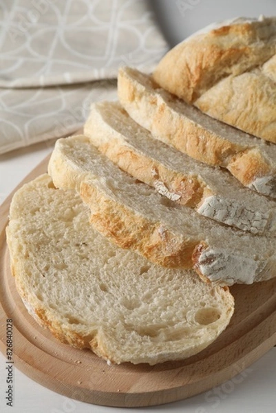 Obraz Freshly baked cut sourdough bread on white wooden table