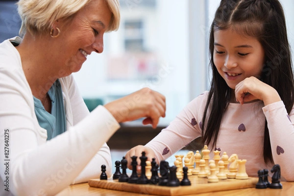 Fototapeta Grandmother, girl and learning chess in home to play for social or critical thinking skills, growth and development for strategy. Grandma, child and checkmate or logical game for memory and bonding.