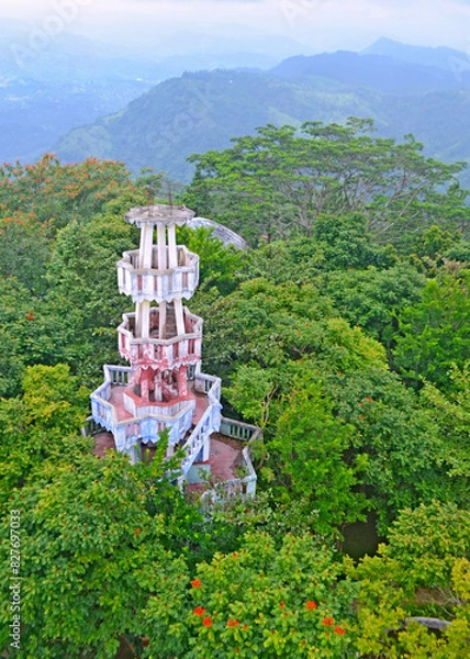 Fototapeta White concrete observation tower middle of a natural forest Ariel view with green exotic trees 