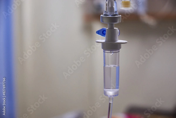 Fototapeta Close-up of slow iv fluid intravenous drip saline with blurred background in a hospital room, medical concept with copy space