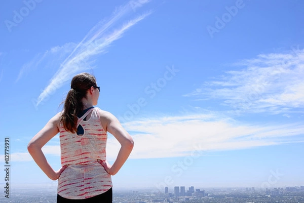 Obraz Woman with ponytail looking at city skyline
