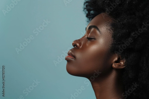 Fototapeta A close up of a black woman's face with her eyes closed looking to a side