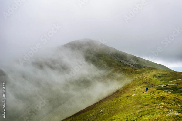 Fototapeta Mountain hiker  in clouds