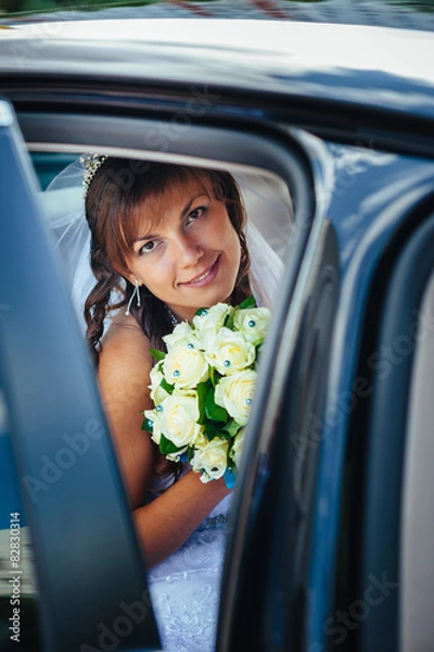 Fototapeta close-up portrait of pretty shy bride in a car window