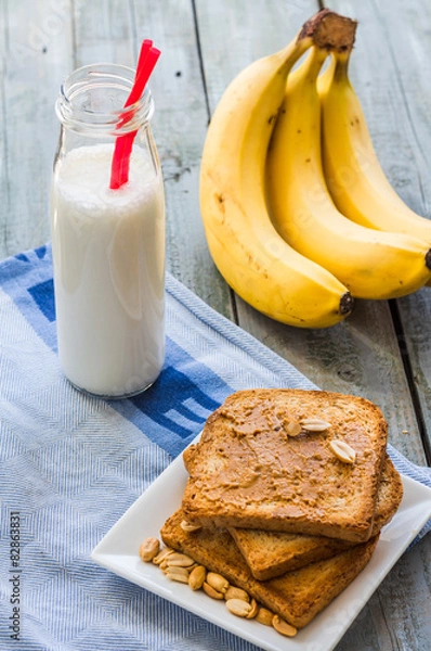 Fototapeta banana smoothie, toast with peanut butter, roasted peanuts, brea
