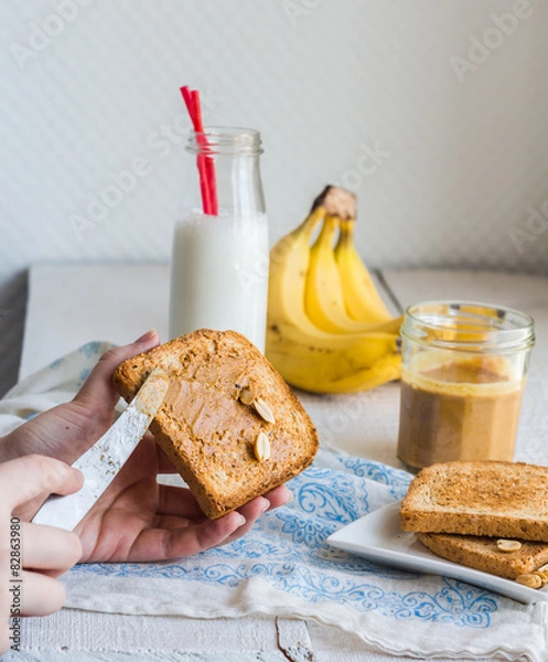 Fototapeta banana smoothie, toast with peanut butter, roasted peanuts, brea