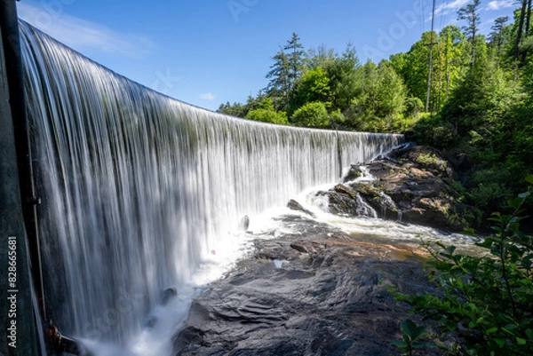 Fototapeta A curved curtain of water flowing over the perfectly level dam that forms Lake Sequoyah blocking the Cullasaja River, Highlands, North Carolina