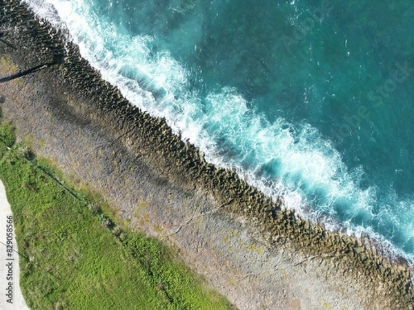 Fototapeta Rocky shore if a beach in San Andres Island, Colombia. The waves crushes against the shore and produce white foam and beautiful patterns
