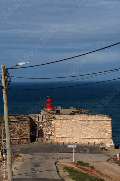 Fototapeta Fort of Sao Miguel Arcanjo Lighthouse in Nazare. View from the hill to the beach 'Praia da Nazaré', Praia do Norte and city of Nazaré, Portugal
