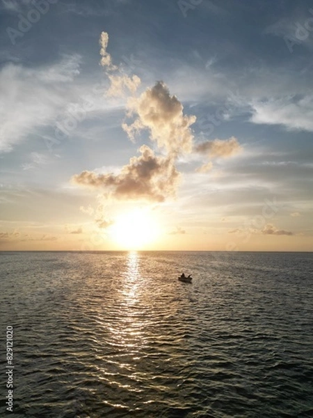 Fototapeta Beautiful sunset scene with the shilouette of a boat with two people. View from above with aereal view from a drone. Picture from san andres islands, Colombia.