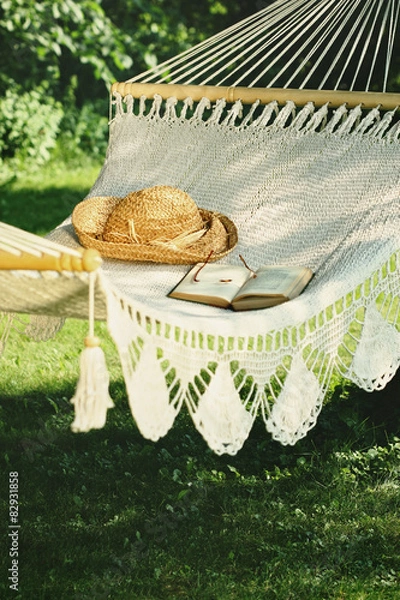Fototapeta Crocheted hammock with straw hat and book