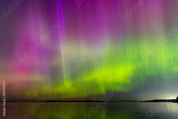 Fototapeta Night time skies light up in vibrant colors thanks to the Northern Lights over Washington state