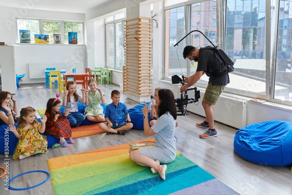 Fototapeta Cameraman films the joyful play and creative exploration of children at a preschool