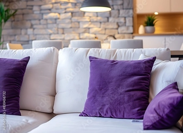 Obraz Modern living room interior with a white sofa, purple pillows and decorative stone wall paneling on the walls, a dining table in the background