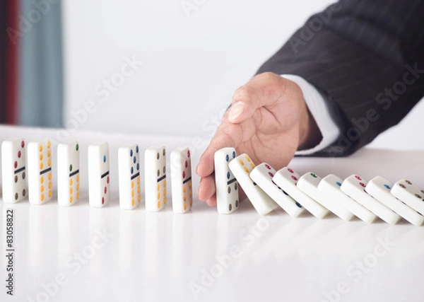 Obraz Concept for problem solving - hand stopping falling dominoes