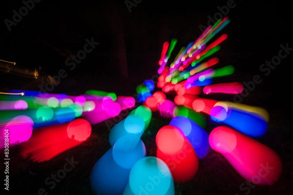 Obraz Light painting abstract background. Colorful light balls, long exposure. Abstract butterfly against a black background. Zoom burst effect.