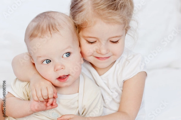 Fototapeta happy little sister hugging her brother