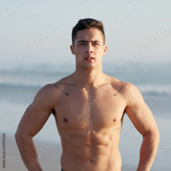 Obraz Fitness, muscles and portrait of man on beach for workout, exercise and training outdoors for surfing. Nature, athlete and confident person by sea and ocean for wellness, health and water sports