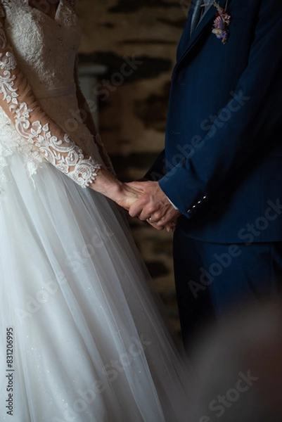 Obraz des mariés se tiennent la main pendant une cérémonie