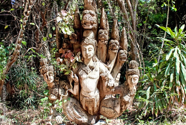 Fototapeta Mystical Wooden Sculpture Harmoniously Placed in a Lush Forest Setting