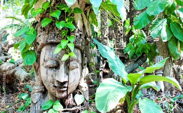 Fototapeta The serene Buddha head nestled in the forest reflects a harmonious blend of nature and spirituality