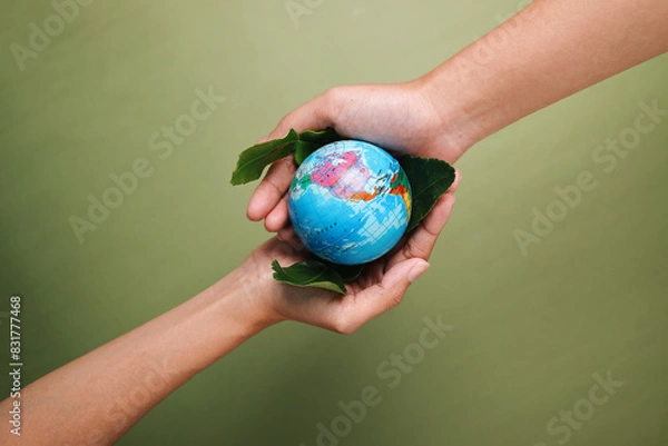 Fototapeta Two Hands Holding Globe On Leaf Over Green Background. Save The Earth. World Environment Day